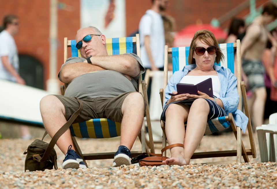  Time for a nap: A couple relax on some deck chairs in the colourful beach town of Brighton