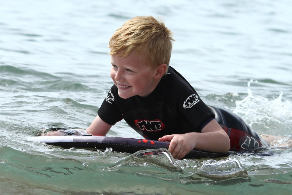  A young lad enjoys the water off the Devon coast as the sun shines down on the UK