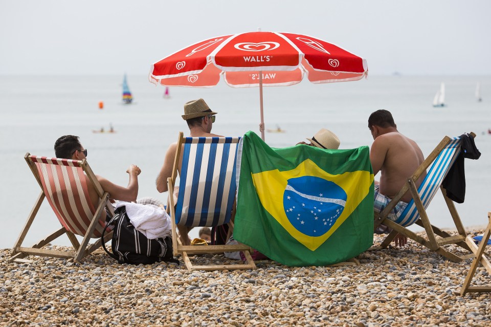  Sun worshippers get into the Olympic spirit on Brighton beach displaying a Brazilian flag as they soak up the sun