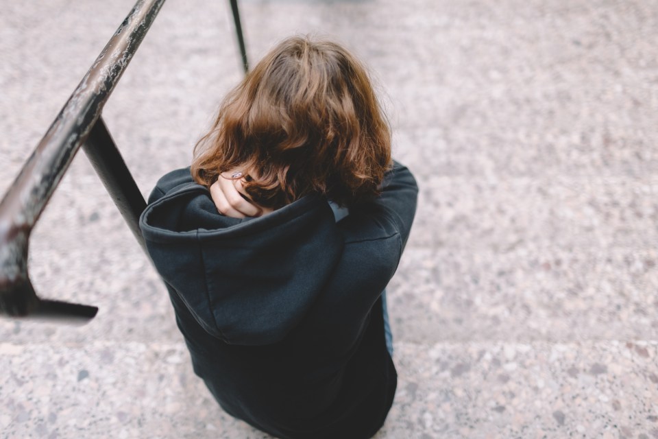 Depressed teenager sitting on the stairs