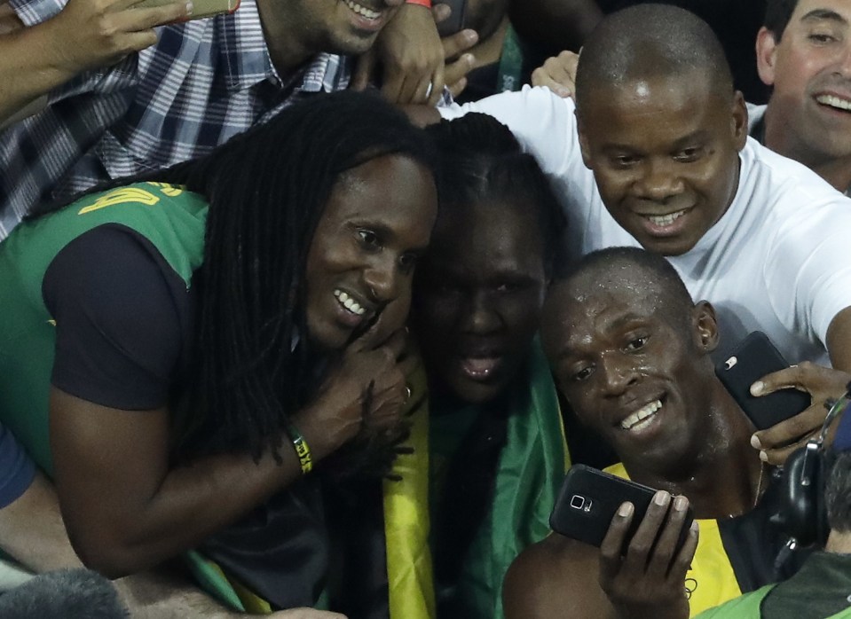  Usain Bolt poses for a selfie with his fans following his record-breaking win