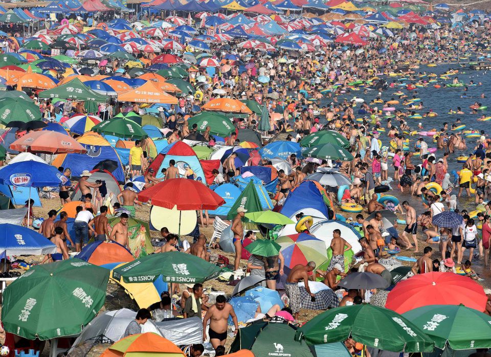  Thousands of people crowd a beach in Dalian city, in eastern China yesterday