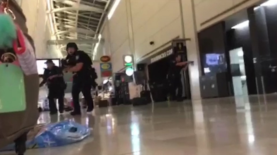  Armed cops charge through the airport with their guns drawn during the terror scare