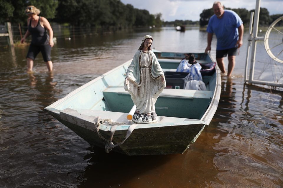  Leigh Babin and her husband TJ Babin bring items they recovered from their flooded home to shore along with a statue of the Virgin Mary that they found in the flood waters