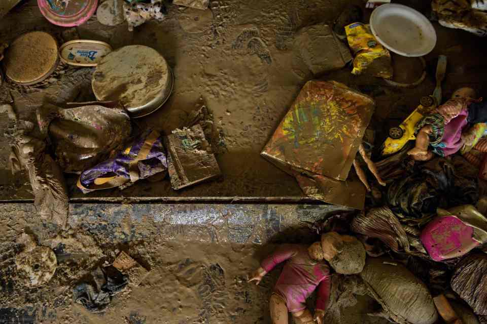  Mud covered belongings are seen on the floor of a home after flood water receded