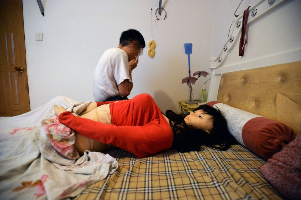  Pictures show Zhang sobbing as he talks to the doll as it lies on the bed