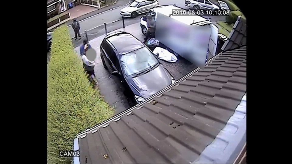  Householder cowers as he is threatened by one of the men while others empty his van