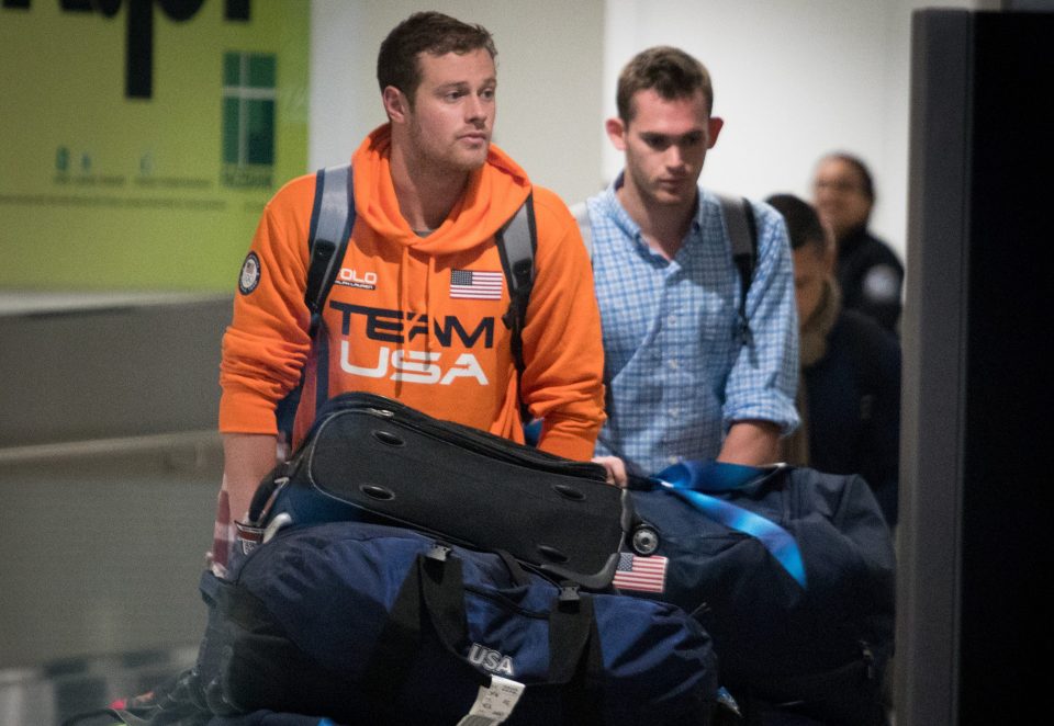 Jack Conger (left) and Gunnar Bentz are escorted through security at Miami Airport