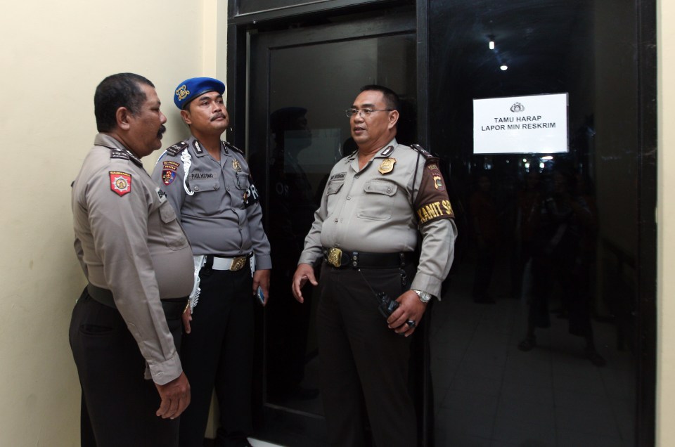  Indonesian police officers guard a door where murder suspect David Taylor is detained