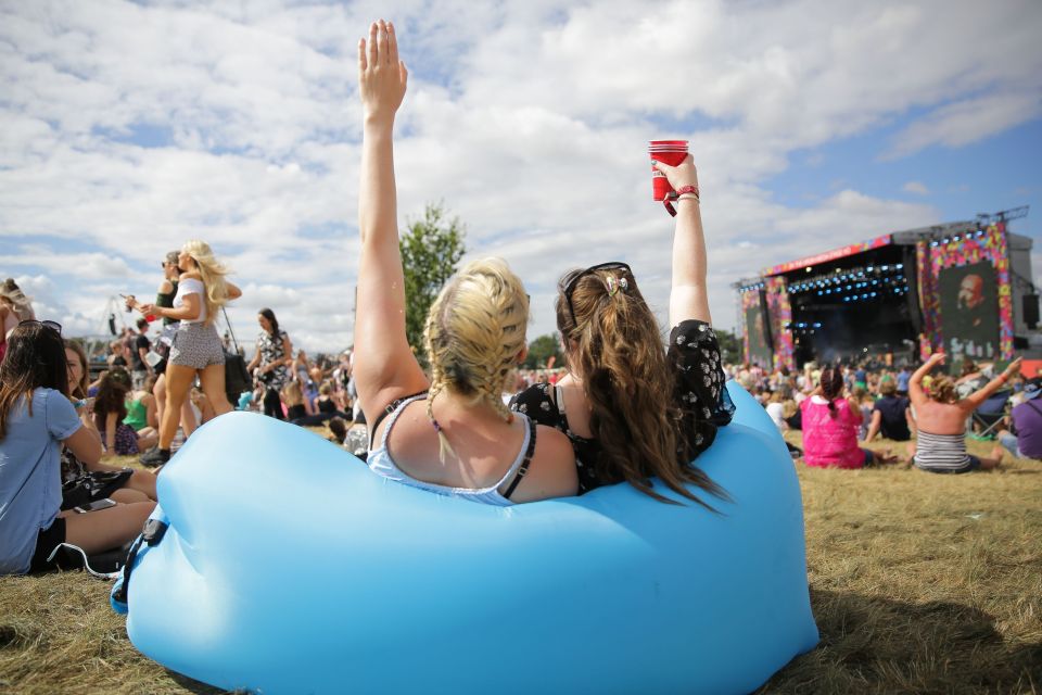  Two girls relax in the sunshine at V Festival in Essex following a wet and windy start to the event