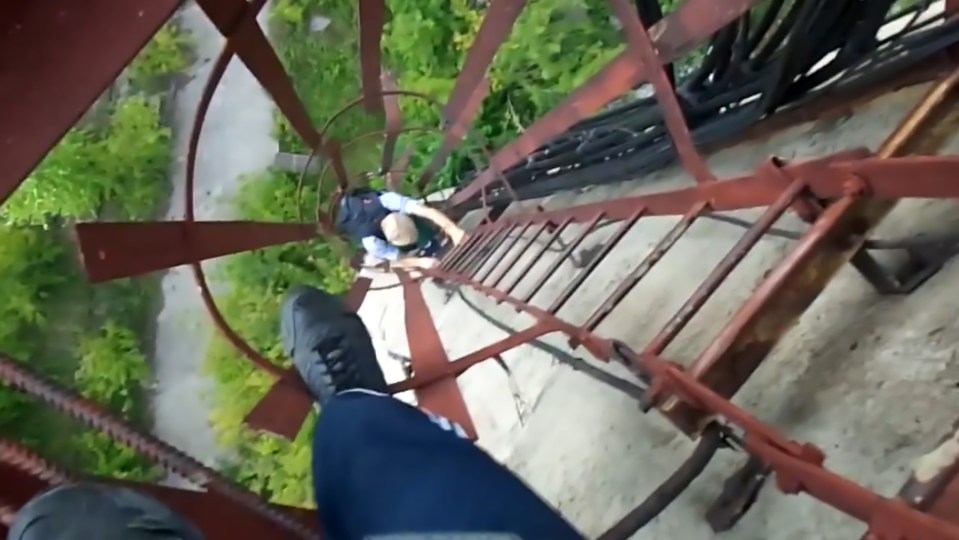  They test the strength of the rusting ladder steps as they near the top of the tower