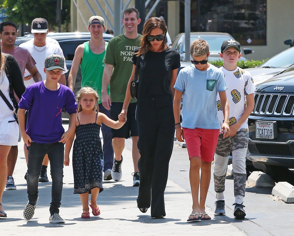  Victoria held hands with the youngest of the family, daughter Harper, closely followed by her sons Romeo and Cruz