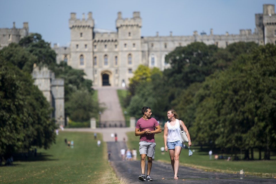  A couple enjoy the sunshine as they stroll along The Long Walk in Windsor Castle