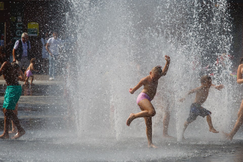  Regime Bagociute, 6, plays in the fountains at Bradford's City Park to cool off