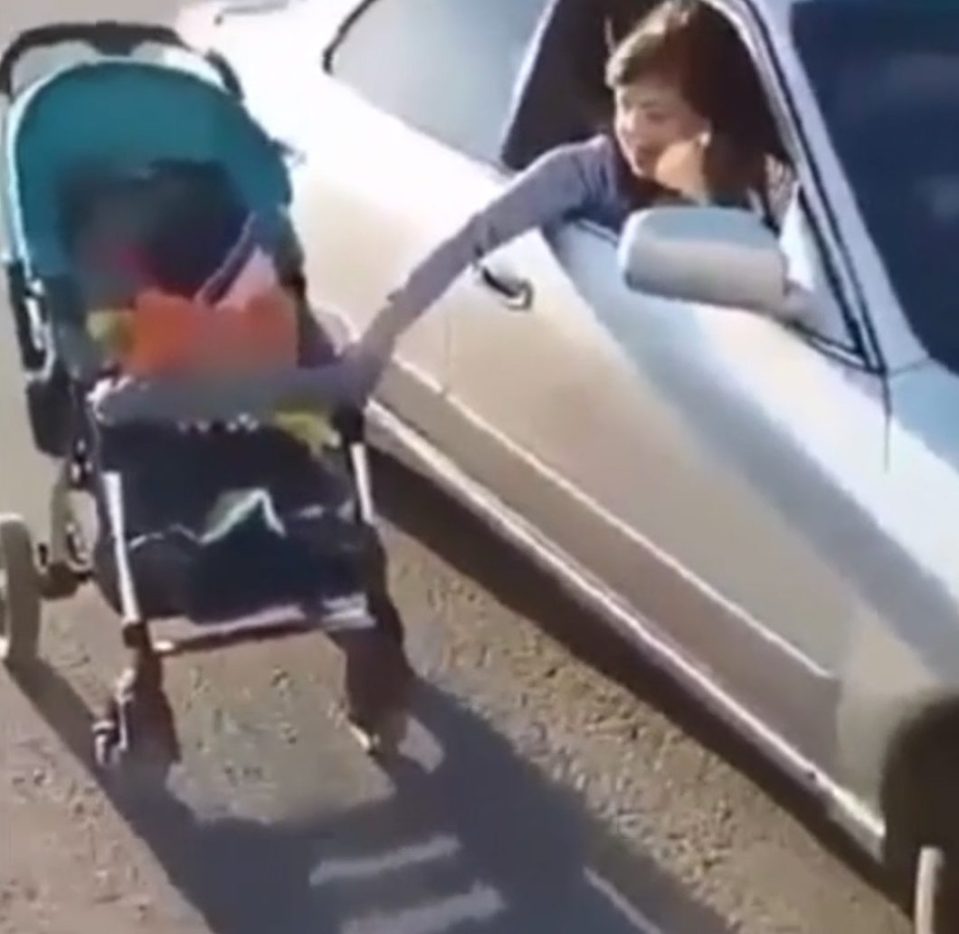  A family friend filmed the stunt on a smartphone showing the woman pushing her toddler in his buggy while driving car