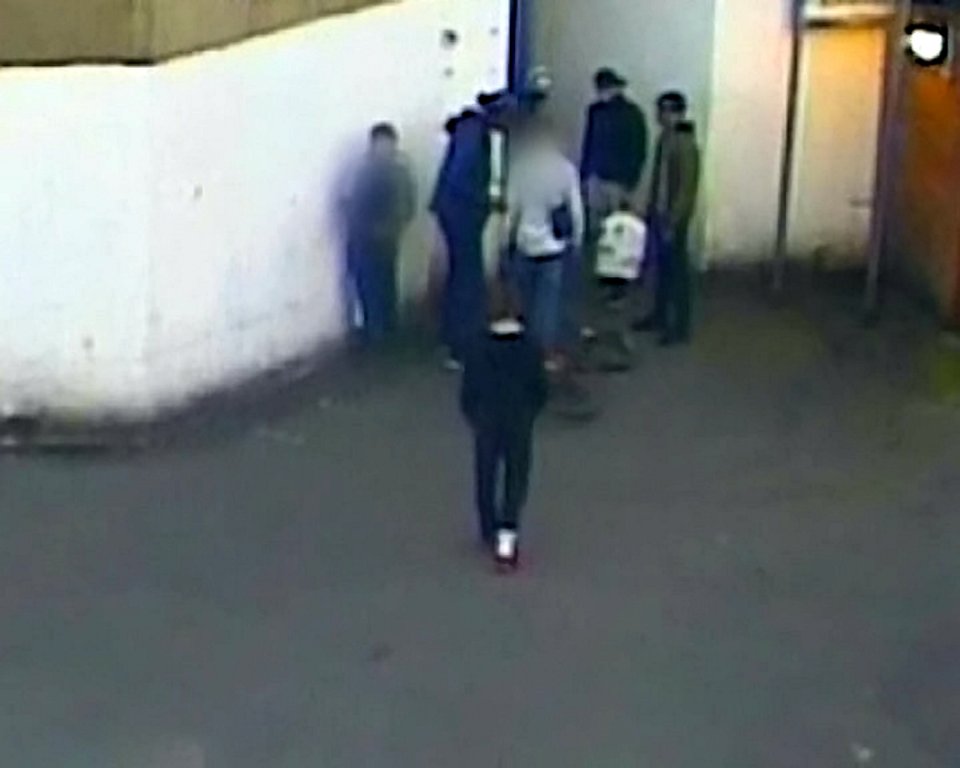  Victim in white top is surrounded by attackers after he places his bike on the floor