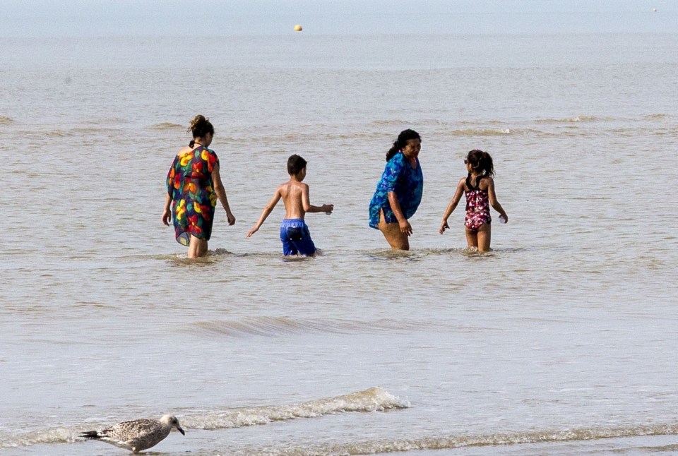  Families are seen paddling in the sea at Camber Sands today after yesterday's tragedy