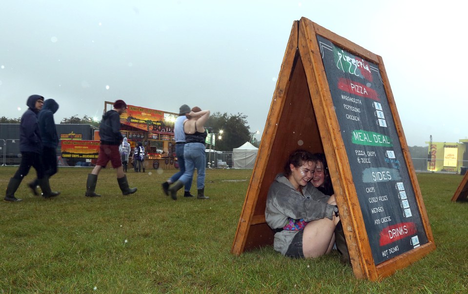  Two women ducked for cover as they sought refuge from the rain under a sign