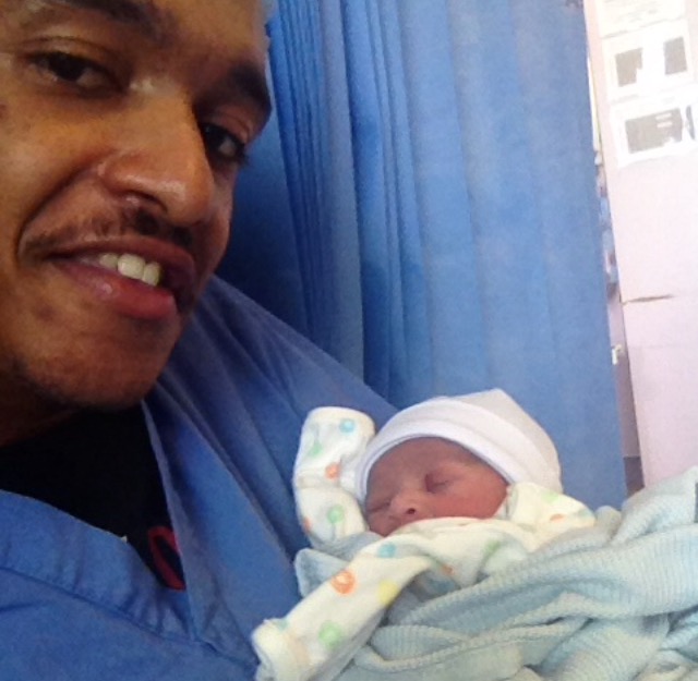  Kobby proudly holds his newborn tot