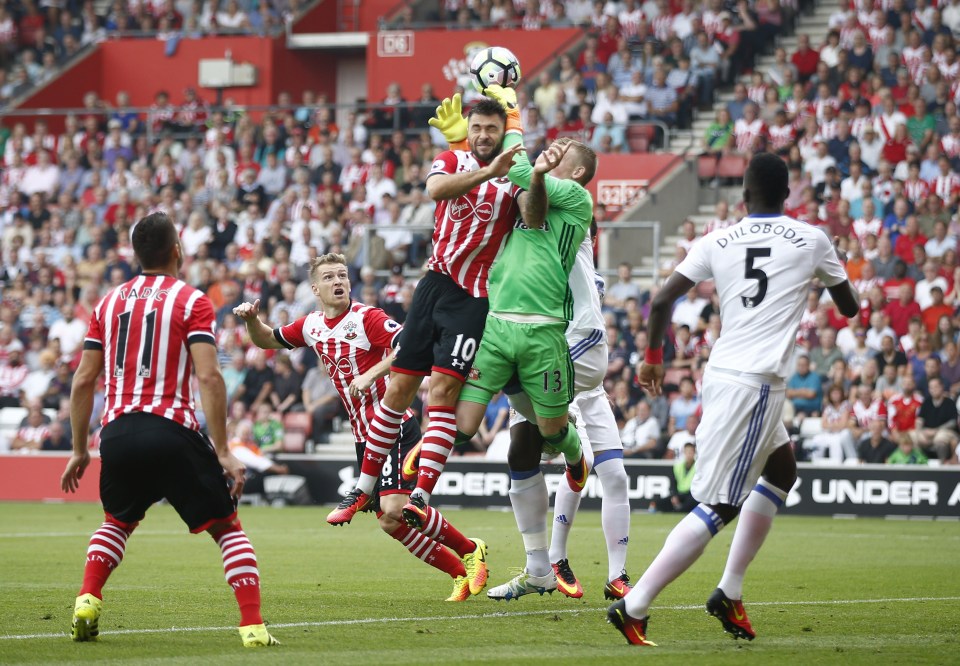 Charlie Austin goes up for a header as he clatters in to Sunderland keeper Pickford 