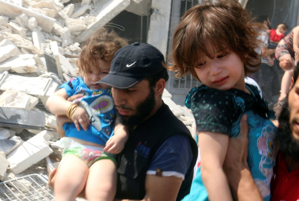  Carnage ... Distressed girls are evacuated after pro-Assad choppers recently attacked Aleppo with indiscriminate barrel bombs