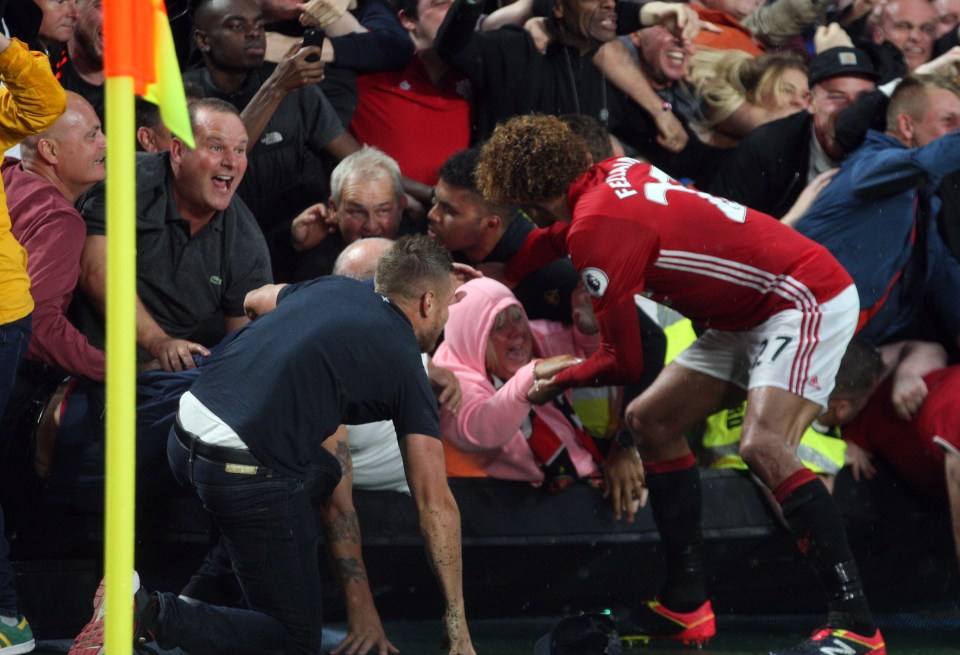  Marouane Fellaini helps a woman from being crushed during Manchester United celebrations at Hull