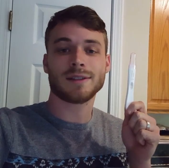  Tim poses with the positive pregnancy test