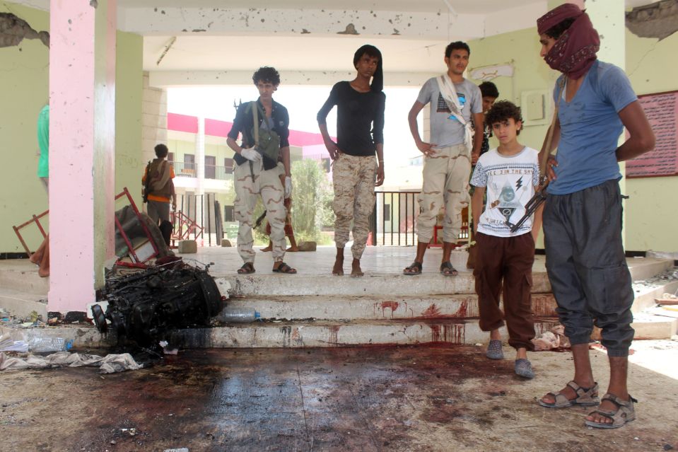  Yemenis look at a blood stained floor at the army recruitment centre