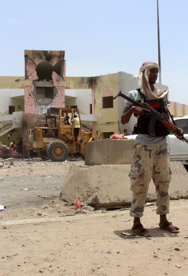  Yemeni security forces stand guard at the site of a suicide car bombing