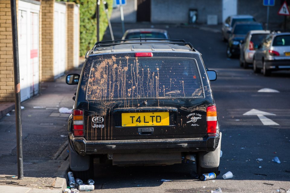  A black Jeep is splattered in orange paint