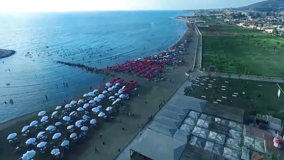  The video shows a packed beach and parasols in an unnamed part of Syria