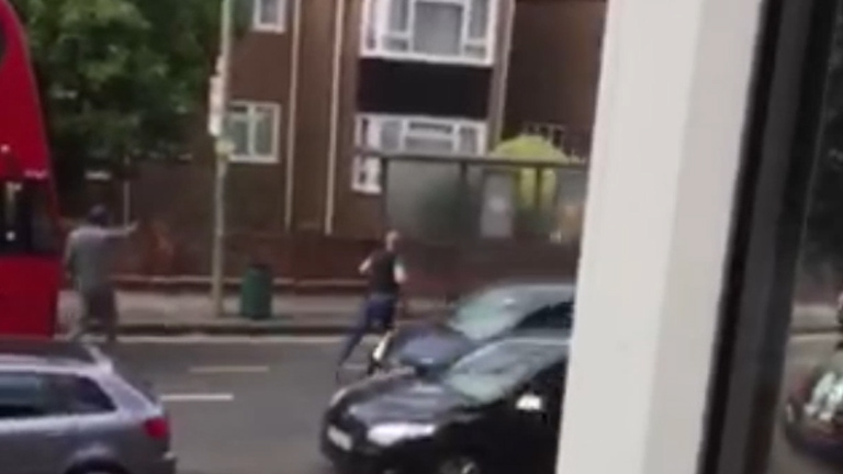  A policeman gives chase in the South London suburb this afternoon