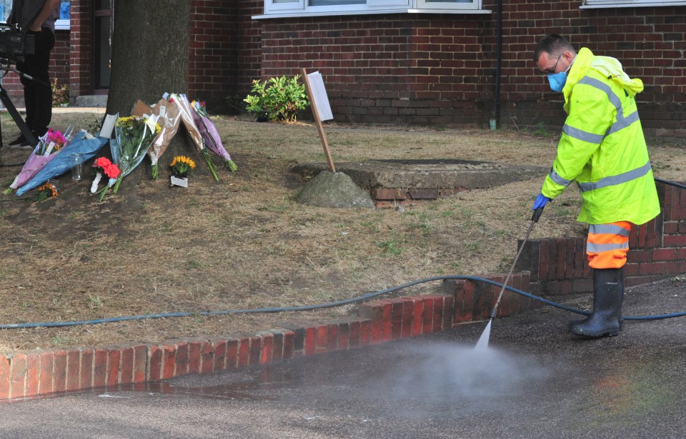  A worker sprays down the deadly crash site in south London