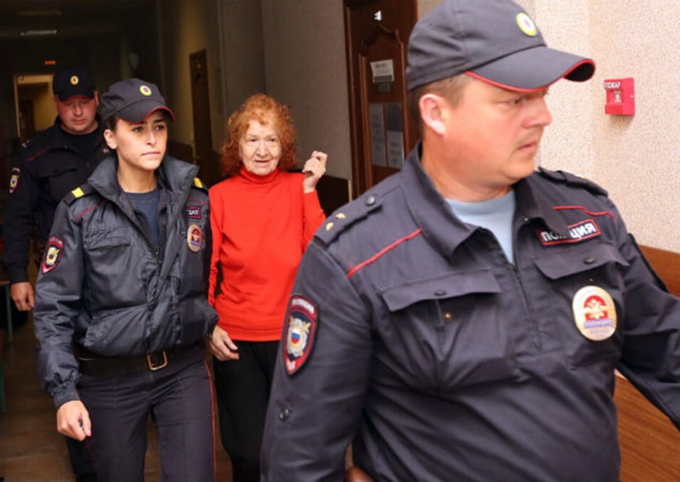  The smiling killer is escorted by guards to the court room