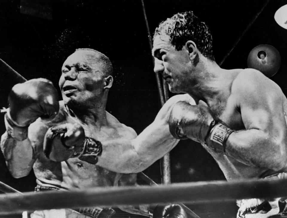 NEW YORK, NY - SEPTEMBER 1: American boxing champion Rocky Marciano (R) throws a right swing to his country fellow heavyweight boxing world champion Joe Walcott, September 1952 in New York, in the fifteenth round of their fight for the title that he takes away. Nicknamed the Rock from Brockton, Rocky Marciano made his name by defeating the former world champion Joe Louis, in 1951. When he retired in 1956, Rocky Marciano was the only undefeated world heavyweight chzmpion, with a professional record of 49 bouts and 49 victories, including 43 by knockout. (Photo credit should read STAFF/AFP/Getty Images)