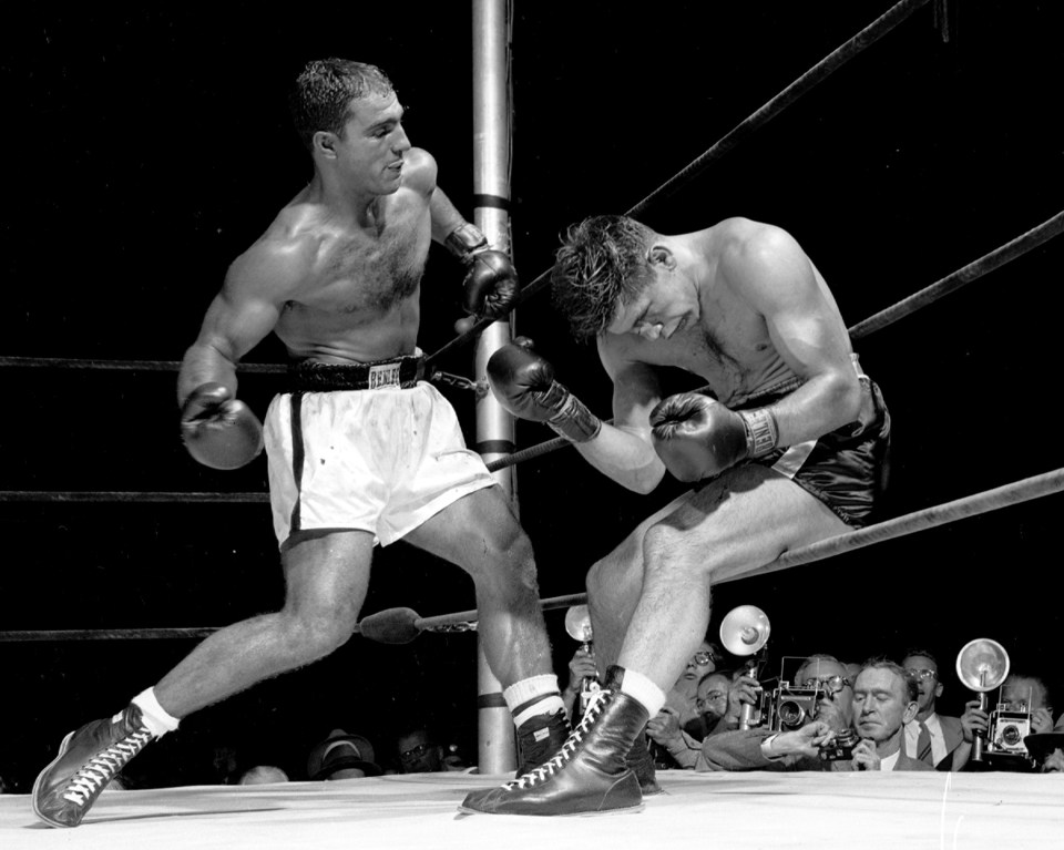 UNITED STATES - SEPTEMBER 24: Rocky by TKO. Challenger Roland LaStarza instinctively but weakly raises his weary arms in defense as heavyweight champ Rocky Marciano cranks his right against his sitting-duck rival in 11th round at Polo Grounds last night. Rocky clubbed dead-game LaStarza into a helpless hulk in winning by a TKO in the 11th round. (Photo by Charles Hoff/NY Daily News Archive via Getty Images)