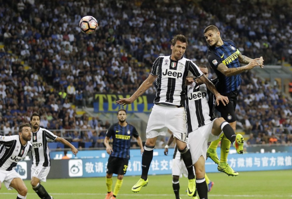 Inter Milan's Mauro Icardi, right, scores on a header past Juventus' Mario Mandzukic, left, and Leonardo Bonucci, center, during the Serie A soccer match between Inter Milan and Juventus at the San Siro stadium in Milan, Italy, Sunday, Sept. 18, 2016. (AP Photo/Antonio Calanni)