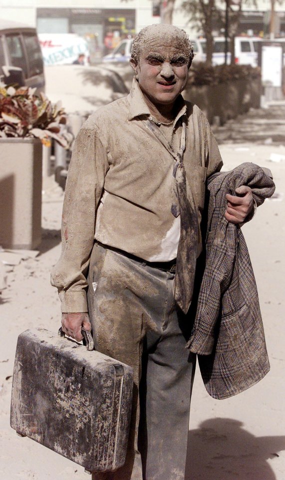 A shocked man walks in the street near the Twin Towers