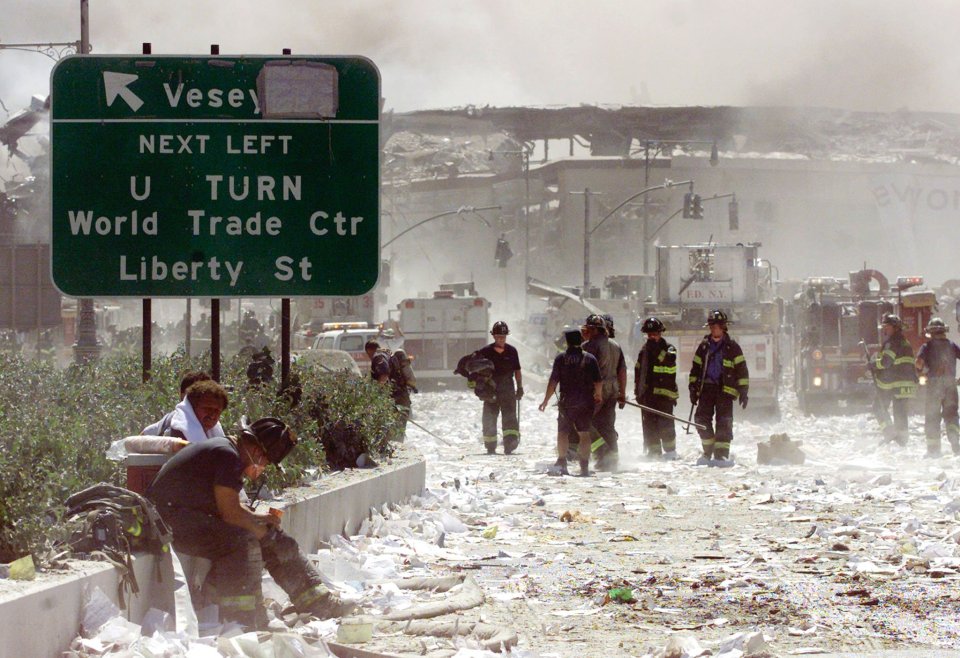 A group of firefighters walk near the remains of the destroyed World Trade Center