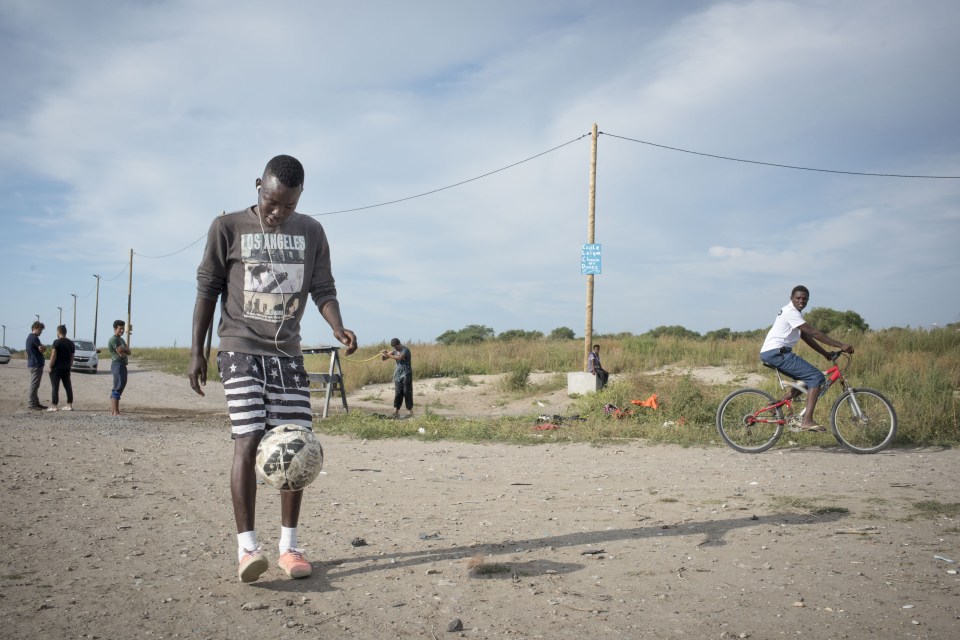  A  boy returns from playing football at a purpose built field.