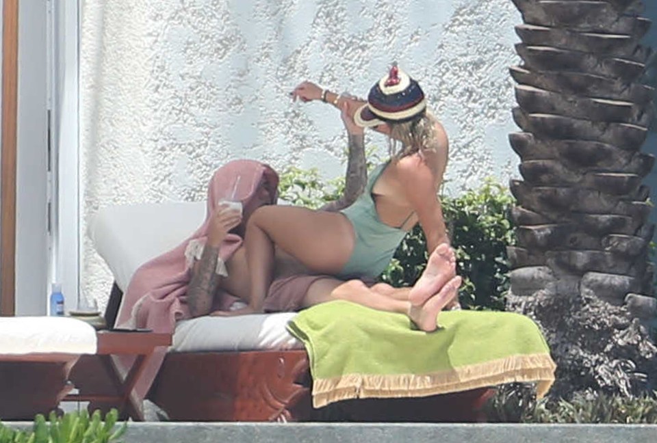  Sofia flashes some side boob as she joins Justin on a sun lounger