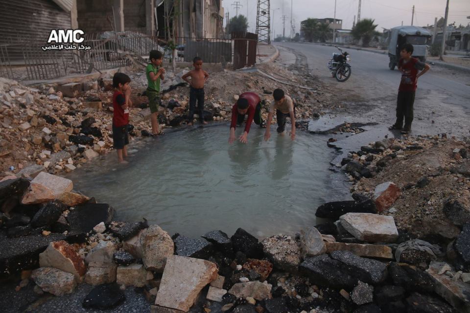  The children of Aleppo play in flooded craters made by the violent conflict