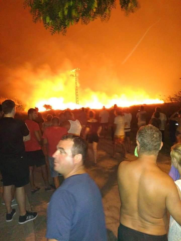  Locals look on in amazement at the raging fires in the distance