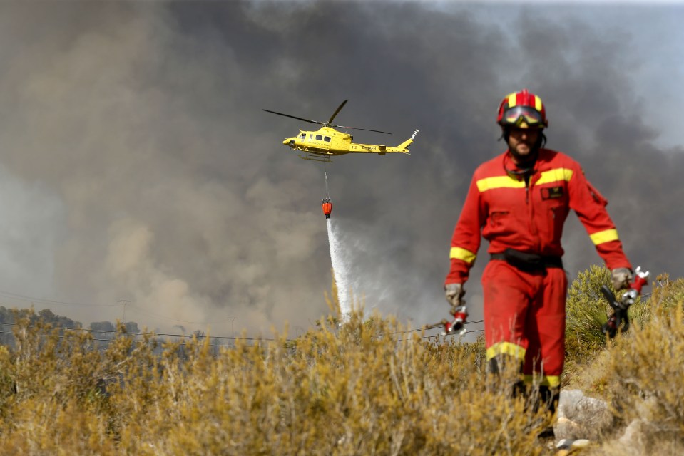  A firefighter works on the arid mountainside where the blaze took hold