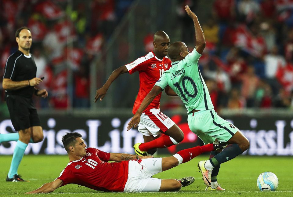  Portugal's Joao Mario feels the full force of another Xhaka tackle