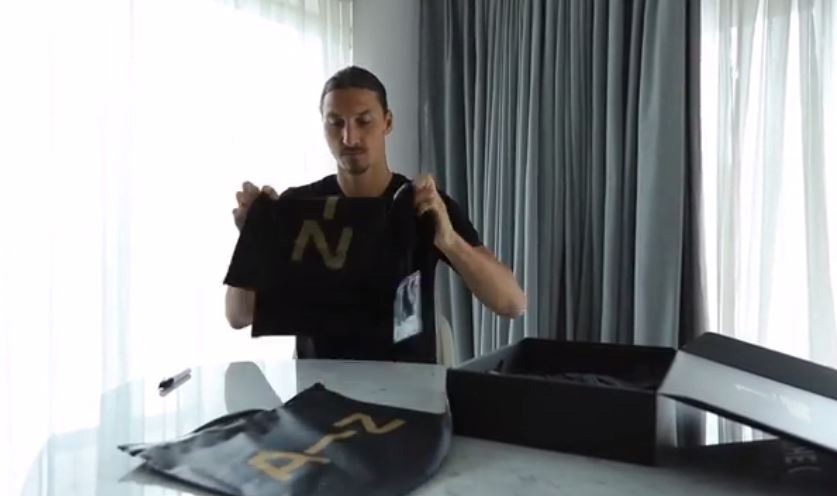 Zlatan Ibrahimovic folds away the training top as he prepares to send his package