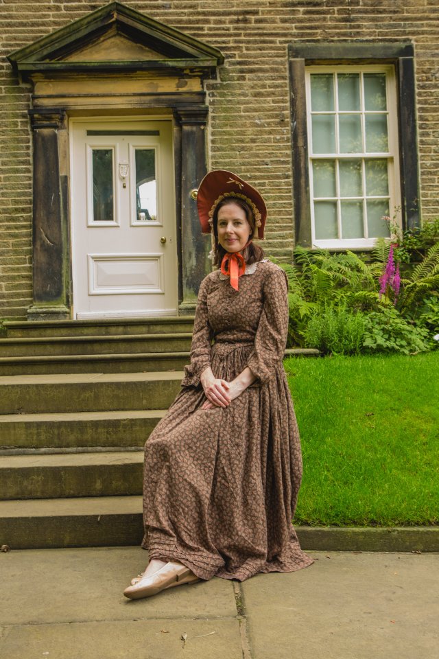 She pauses in front of her family home in Haworth, near Keighley