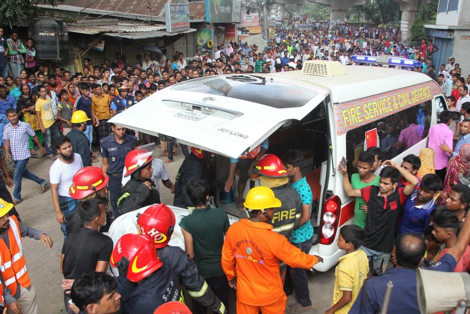  Firefighters carry a victim to an ambulance after an explosion in a factory