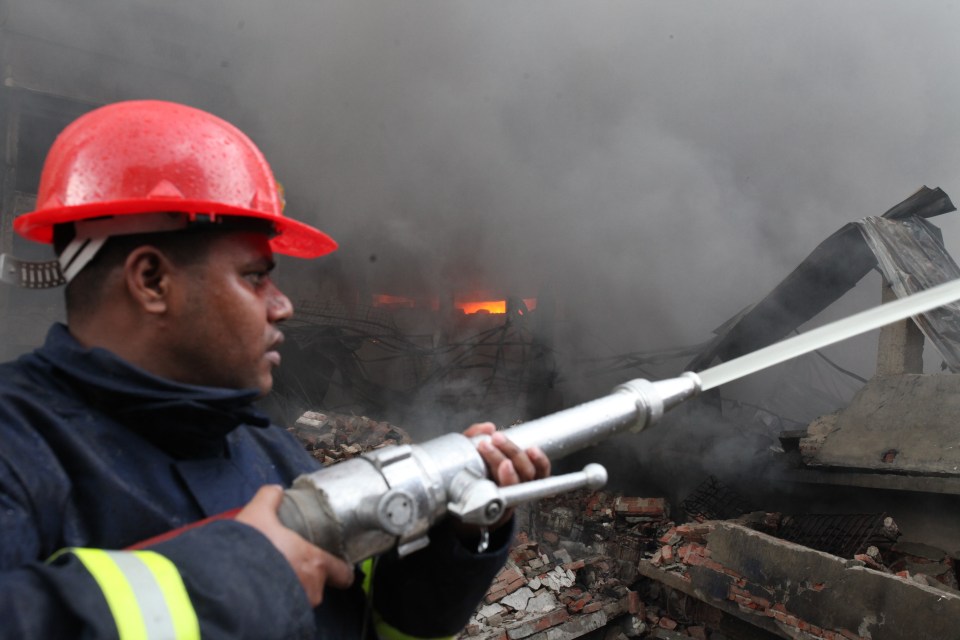  Fire fighters with the help of locals try to douse a fire originated following a boiler explosion