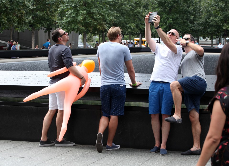  The group of men were confronted by a police officer and asked to leave the area where the Twin Towers fell after taking selfies with the plastic toy